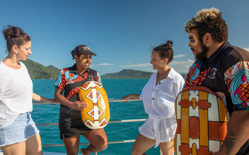 Two people talking to two First Nations people about First Nations art